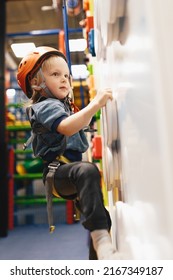 Happy Child In Red Helmet On Climbing Class At Indoor Climbing And Bouldering Centre. Climbing Kindergarten For Elementary Age Kids