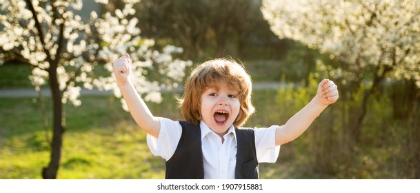 Happy Child At School Backyard. Blooming Garden. Spring Boy At Park