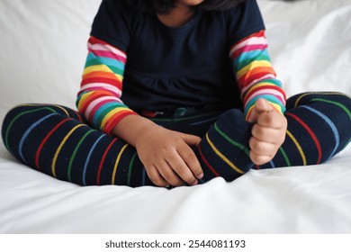 A Happy Child is Sitting Comfortably, Relaxed in Cozy Colorful Striped Socks at Home - Powered by Shutterstock