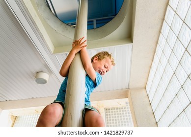 Happy Child Sliding Down The Pole Of A Fire Station.