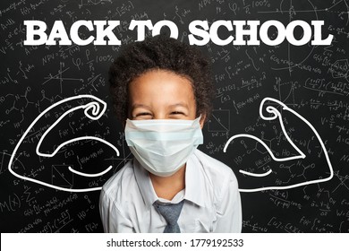 Happy Child Student In Medical Protective Face Mask On Blackboard Background