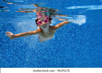 Happy Child Swims Underwater In Swimming Pool. Kids Sport