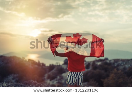 Happy child teenage girl waving the flag of Canada while running at sunset