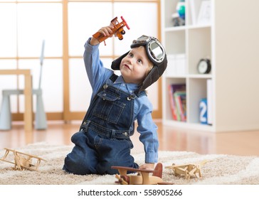 happy child toddler boy playing with toy airplane and dreaming of becoming a pilot - Shutterstock ID 558905266