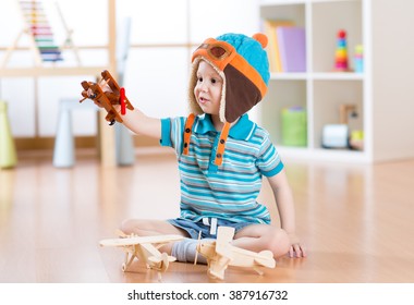 Happy Child Toddler Playing With Toy Airplane And Dreaming Of Becoming A Pilot