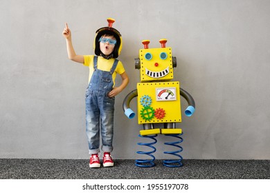 Happy Child With Toy Robot. Funny Kid Playing At Home. Education, Creative, Artificial Intelligence And Innovation Technology Concept