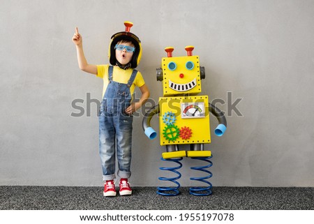 Happy child with toy robot. Funny kid playing at home. Education, creative, artificial intelligence and innovation technology concept