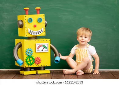 Happy Child With Toy Robot In Preschool Classroom. Funny Kid Playing In Kindergarten. Education, Creative And Innovation Technology Concept