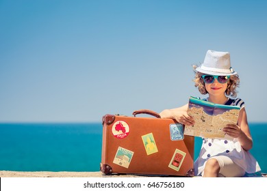 Happy Child With Vintage Suitcase And City Map. Kid Having Fun On Summer Vacation. Travel And Adventure Concept