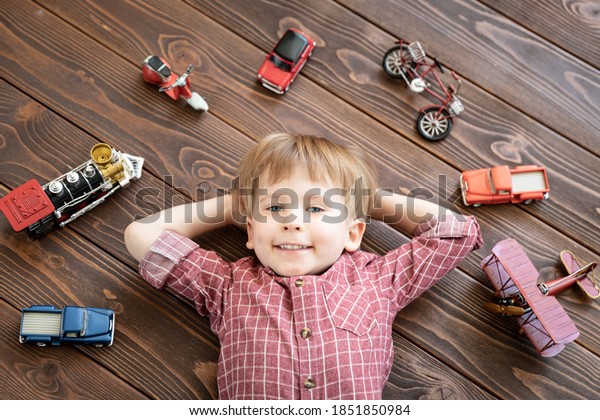 Happy\
child with vintage toys. Funny kid playing at\
home.