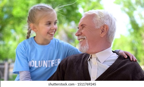 Happy child volunteer hugging male pensioner smiling each other, old people care - Powered by Shutterstock