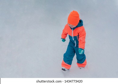 Happy Child In Winter Warm Clothes Run Through Snow On Eve In Village Yard. Fence With Peeling Paint, Rustic Fun, The Joy. Child Are Happy On Vacation In The Country