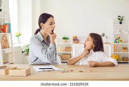 Happy child and young female speech therapist or mother doing mouth exercise, working on pronunciation problems, correcting sounds, fixing stuttering stammering impediment, and having fun together