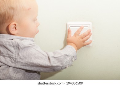 Happy Childhood. Baby Boy Turning On Or Off The Light. Child Kid Playing With Switch. At Home.