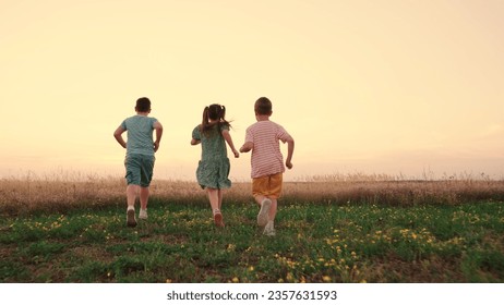 Happy childhood. Teenagers play running. Funny children play in park, friends run in summer. Child run on grass, sunset. Happy boy, girl run in field, playing in nature. Family, weekend outdoors.