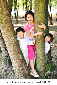 Happy children between the trees in forest