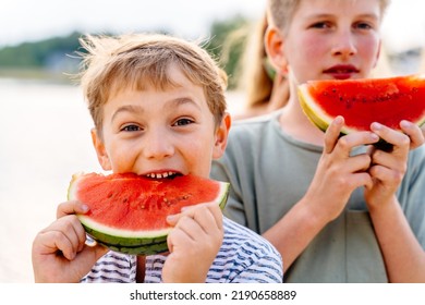 Happy Children Boy With His Brother Enjoy Summer Eating Juicy Watermelon Having Picnic At Summer Sunny Day At Nature. People Vacation Outdoor Activities Concept.