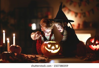 happy children in costumes of witch and vampire in a dark house in holiday Halloween