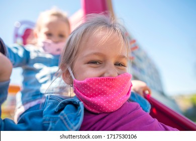 Happy children in eastern europe playing with face masks on playground during quarantine covid19. Slovakia