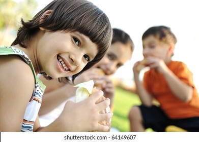 Happy Children Eating Together In Nature