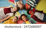 Happy children, friends and costume in class above on floor for dress up or casual day at school. Top view, portrait or young kids with cosplay outfit, hero or fairy tale in halloween classroom