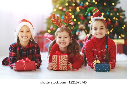 Happy Children Girls With Christmas Gifts Near Christmas Tree In Morning
