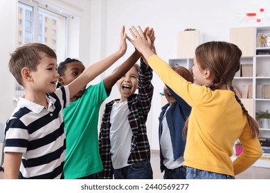 Happy children giving high five at school - Powered by Shutterstock