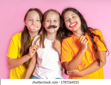 Happy Children Hold Fake Mustache And Lips On A Pink Background. Beauty Salon.  Hair Design Salon. Salon Photobooth. 