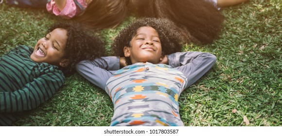 Happy Children Kids Laying On Grass In Park 