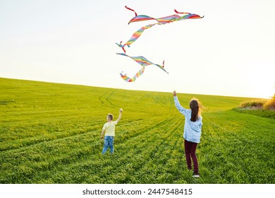 Happy children launch a kite in the field. Little boy and girl on summer vacation.