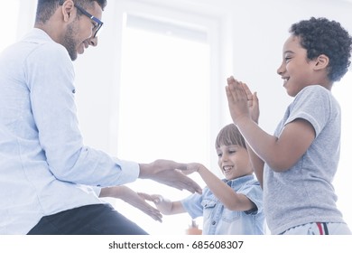 Happy Children Play Clapping Hands With Teacher At His Home