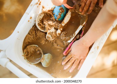 Happy Children Play With Sand And Water In Sensory Baskets On The Outdoor Sensory Table, Sensory Early Development, Montessori. Baby Hands With Sand And Water Close Up, Soft Focus