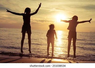 Happy children playing on the beach at the sunset time - Shutterstock ID 251038534