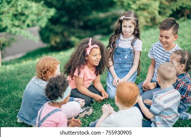 Happy Children Playing In The Park In The Summer. Multicultural Group. The Concept Of Childhood, Friendship And Intercultural Communication.