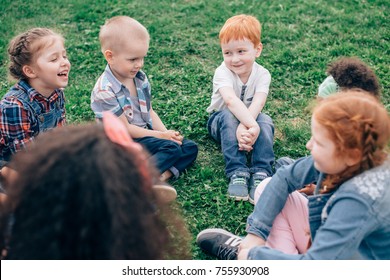 Happy Children Playing In The Park In The Summer. Multicultural Group. The Concept Of Childhood, Friendship And Intercultural Communication.