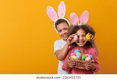 A happy children with rabbit ears on her head with a basket full of Easter eggs - Powered by Shutterstock