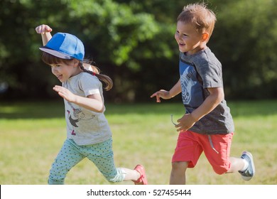 Happy Children Running Around Outside Playing Catch-up Concept.