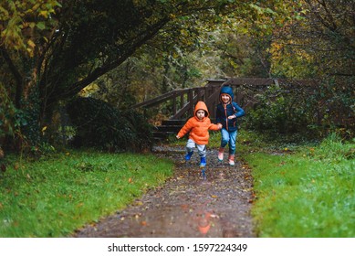 happy children running at park at rainy day