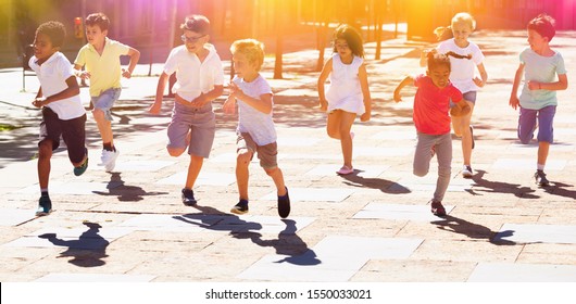 Happy Children Running In Race And Laughing Outdoors At Sunny Day