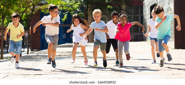 Happy Children Running In Race And Laughing Outdoors At Sunny Day