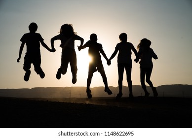 Happy children shadows jumping at sunset. holiday and vacation concept. - Shutterstock ID 1148622695