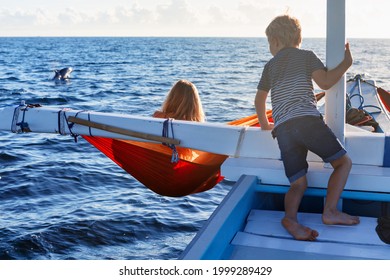 Happy children sit on boat. Dolphins watching adventure tour on tropical islands. Water activity, active children lifestyle, summer vacation travel with kids at family resort. 