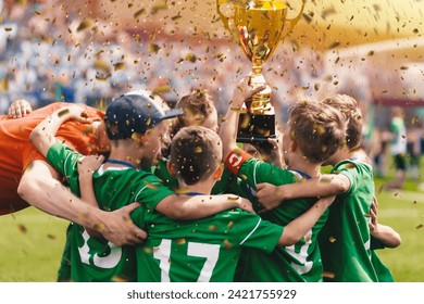 Happy children in sports team celebrating victory. Kids winning the game and rising golden cup. Kids football team huddling in circle and jumping in happiness. Youth sports team succeed in tournament - Powered by Shutterstock