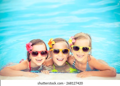 Happy Children In The Swimming Pool. Funny Kids Playing Outdoors. Summer Vacation Concept