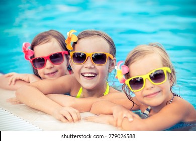 Happy Children In The Swimming Pool. Funny Kids Playing Outdoors. Summer Vacation Concept