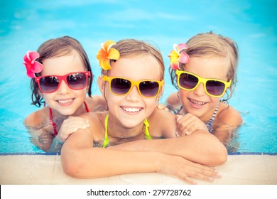 Happy Children In The Swimming Pool. Funny Kids Playing Outdoors. Summer Vacation Concept