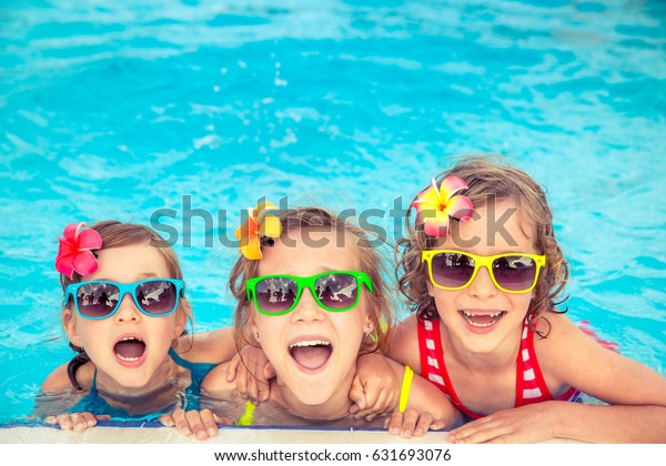 Happy children in the swimming pool.\
Funny kids playing outdoors. Summer vacation\
concept