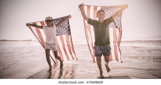 Happy children taking an american flag on the beach - Powered by Shutterstock