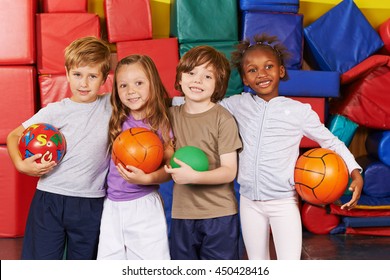 Happy children as team with different balls in a gym of a preschool