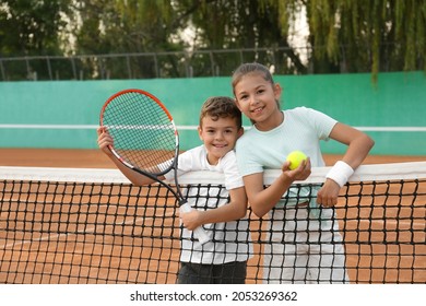 Happy children with tennis racket and ball on court outdoors - Powered by Shutterstock